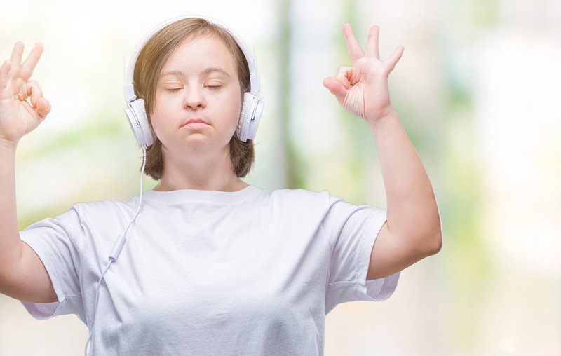 Calm woman meditating with headphones on.