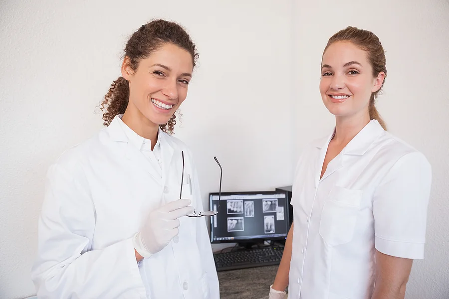 Dentist and assistant studying x-rays on computer