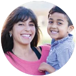 Mother smiling as she holds up her son.