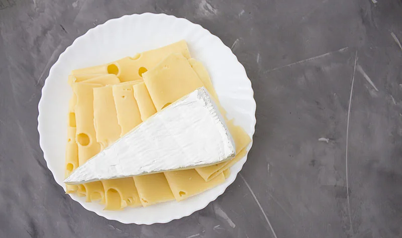 slices and a wedge of cheese on a plate