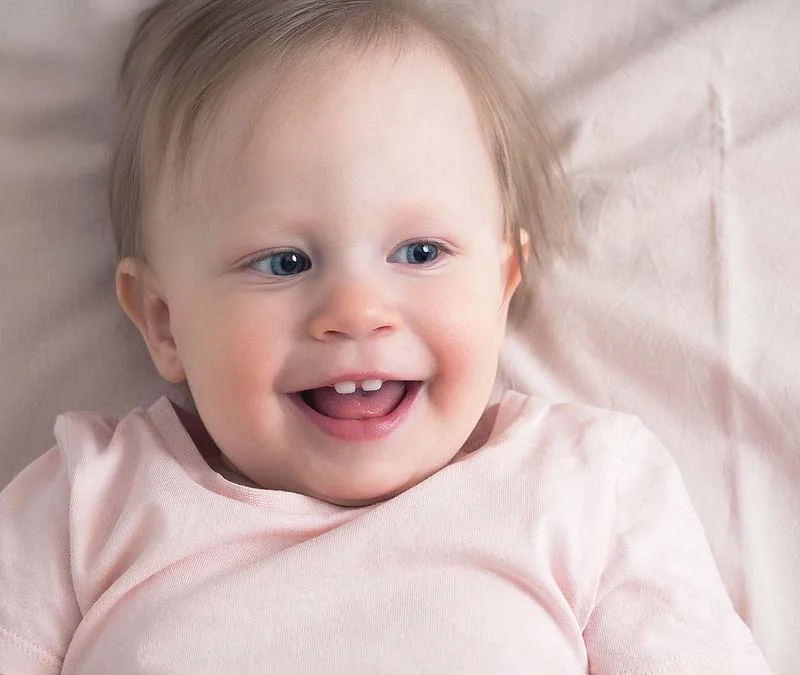 smiling baby with two teeth