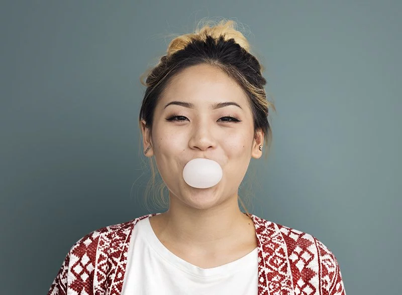 Woman Blowing a Bubble with Chewing Gum