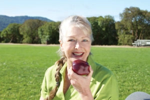 Woman eating an apple mini dental implants Clinton Twp, MI
