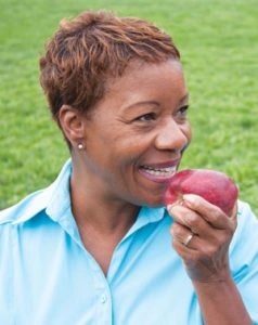 Woman eating an apple post bone grafting